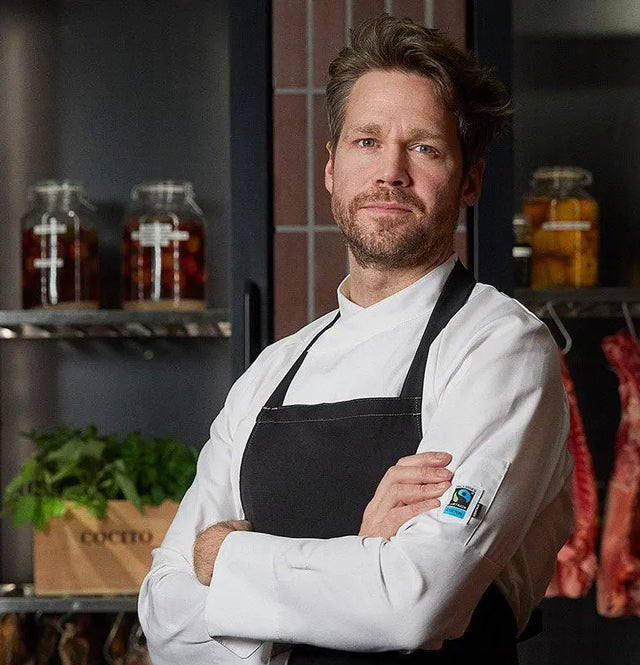 Chef wearing a premium white double-breasted coat in a professional kitchen